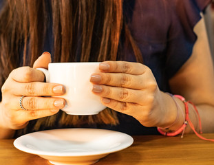 Fototapeta na wymiar Mujer independiente con hermosas manos, tomando una taza de café