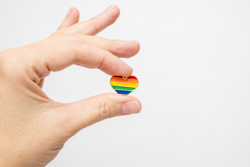 Hand holding rainbow gay pride symbol heart as lgbt rights concept, copy space