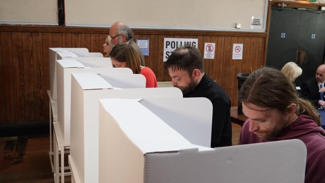 Voters voting at Polling Place / Station. People Stood in line at booths, choosing who to vote for and post Ballot papers in Box