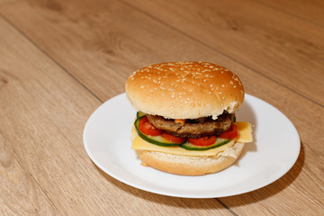 hamburger, cheeseburger on white plate, wooden background 