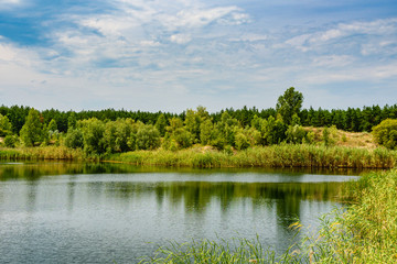 View on a lake in the abandoned sand quarry and dramatic sky