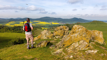 A hiker with a backpack near the city of Kassel on a mountain. The stones have the name...
