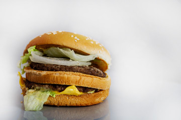 beef burger, with cheese, lettuce and onion, white background, horizontal format, with space on the right