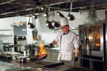 Modern kitchen. Cooks prepare meals on the stove in the kitchen of the restaurant or hotel. The...