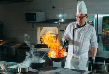 Modern kitchen. Cooks prepare meals on the stove in the kitchen of the restaurant or hotel. The...