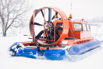View of rescue team Hovercraft. hover craft transport boat crossing frozen river lake on the ice in...