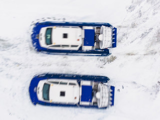 View of rescue team Hovercraft. hover craft transport boat crossing frozen river lake on the ice in the winter snowy day