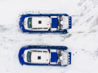 View of rescue team Hovercraft. hover craft transport boat crossing frozen river lake on the ice in the winter snowy day