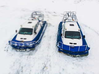 View of rescue team Hovercraft. hover craft transport boat crossing frozen river lake on the ice in the winter snowy day