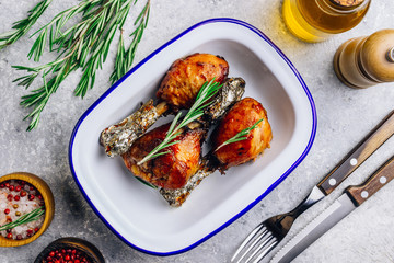Grilled chicken drumstick bbq with rosemary on a stone gray background.