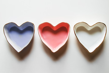 Three plates of hearts on a white background in blue, red and white.