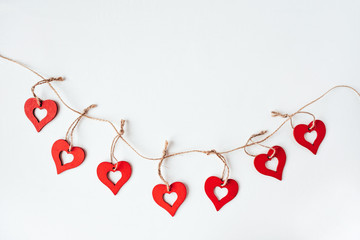 Valentine's day decoration with ornaments in the form of hearts. White wooden background.
