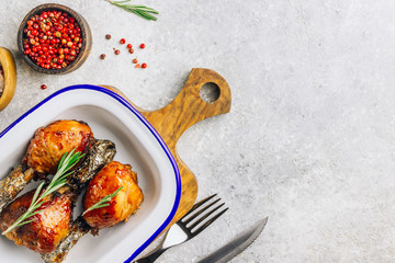 Grilled chicken drumstick bbq with rosemary on a stone gray background.