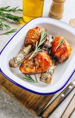 Grilled chicken drumstick bbq with rosemary on a stone gray background.