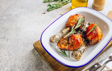 Grilled chicken drumstick bbq with rosemary on a stone gray background.