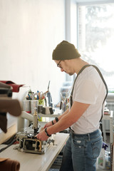 Hipster leather sewer in workshop