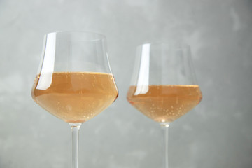 Two glasses of orange wine with glass goblets on a gray background