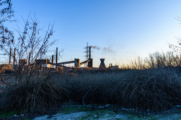 Fototapeta premium View on smoke pipes of the factory at sunset