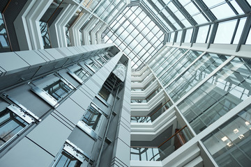 Part of interior of contemporary tall office building with moving elevator