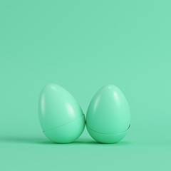 Two green eggs on bright green background in pastel colors. Minimalism concept