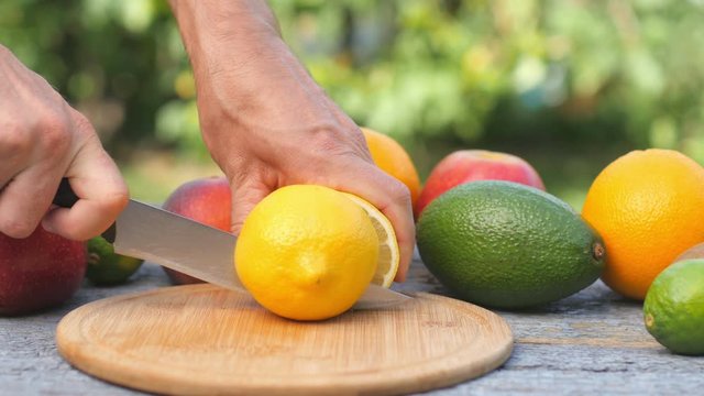 Ripe lemon is ripened on a cutting board. Fresh fruits on the table. Juicy lem cut in half. Avocado Lemon and apple on the background.