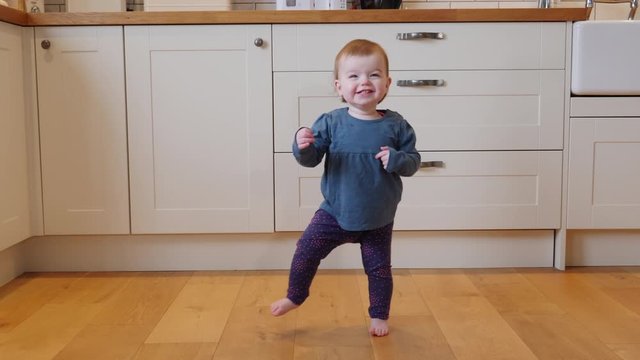 4K: Baby girl / Toddler taking first few steps Walking in the home - Kitchen