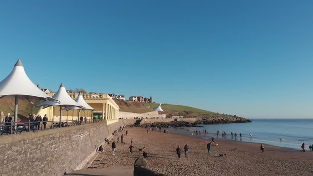 A perfect sunny day on Barry Island Beach in Winter. Families enjoy the beach and the promenade. Blues skies and calm seas, a perfect place for family time by the seaside. 