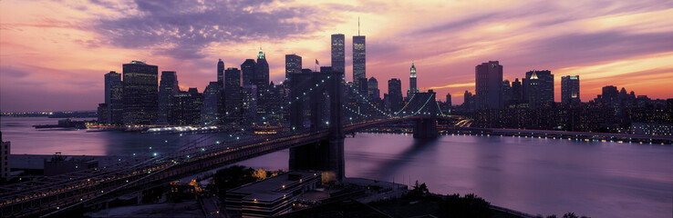 This is the Brooklyn Bridge over the East River and the Manhattan skyline at sunset. there is a...