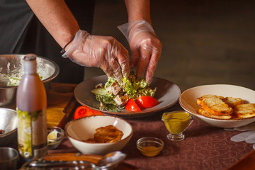 Chef makes a delicious caesar salad. Close-up. Hands in the frame.