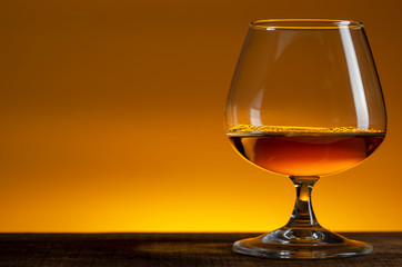 glass of Calvados Brandy and red apples on wooden table