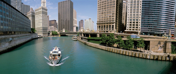 This is a tour boat on the Chicago River during summer. The Chicago Tribune Building, Chicago Sun...