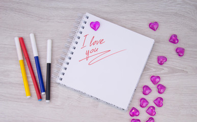 I love a pink letter, a Valentine card, a Notepad with the words I love you and a pen lying on a white background. Valentine day. Love letter. Marker writing