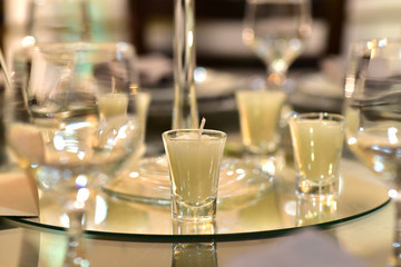 mirrored glass table with decorative candles on blurred background with noise