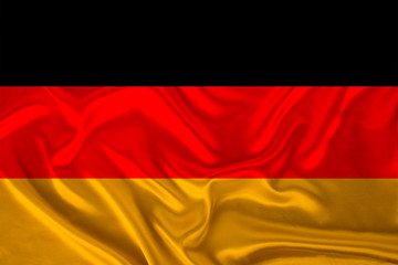 photo of the national flag of Germany on a luxurious texture of satin, silk with waves, folds and highlights, close-up, copy space, travel concept, economy and state policy, illustration