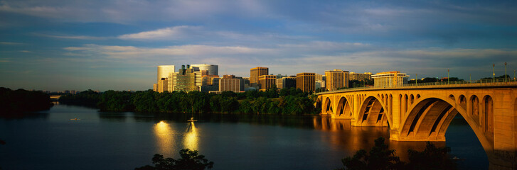 This shows sunrise over the Key Bridge on the Potomac River. The skyline of Rosslyn, Virginia is in...