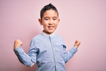 Young little boy kid wearing elegant shirt standing over pink isolated background celebrating surprised and amazed for success with arms raised and open eyes. Winner concept.