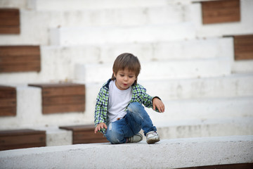 The boy is sitting on a white border. Blurred image - 316641577