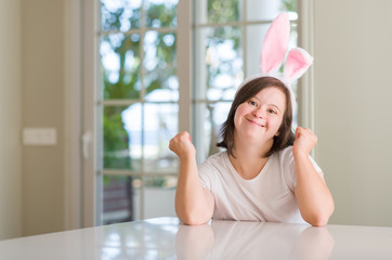 Down syndrome woman at home wearing easter rabbit ears screaming proud and celebrating victory and...