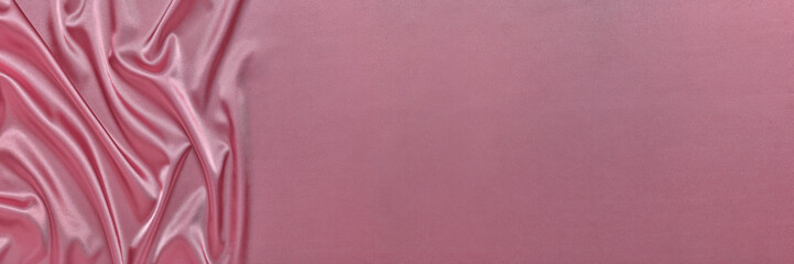 Abstract background from pink silk or satin. Luxury fabric texture with draped. Copy space. Element...