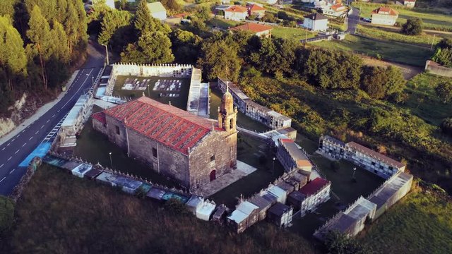 Aerial zoom in shot of a Church in cemetery of Ara&ntilde;o in Galicia, Spain. Clear sunny day.