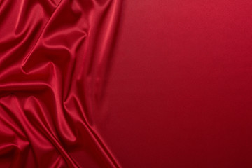 Abstract background from red silk or satin. Luxury fabric texture with draped. Copy space. Element...