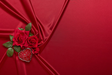 Abstract background from red silk, roses and heart. Fabric texture with draped. Copy space. Element design. Valentine's day.