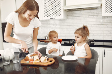 Mother with children. Family have breakfas. Kids in a kitchen