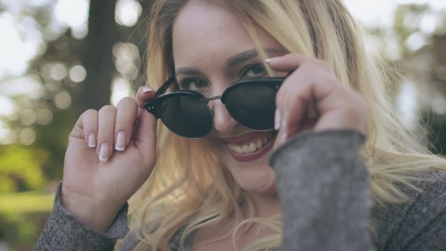 Attractive Blonde Woman Smile Sunglasses Look. Young Caucasian Girl Laugh Summertime Nature Scenery Background. Happy Adult Enjoy Wear Black Spectacles Free Time Activity Slow Motion 4K