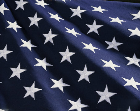 These are the stars of the American flag. They are against their blue field, climbing upward toward the corner of the image as if they were situated on small stairs that move up in levels..