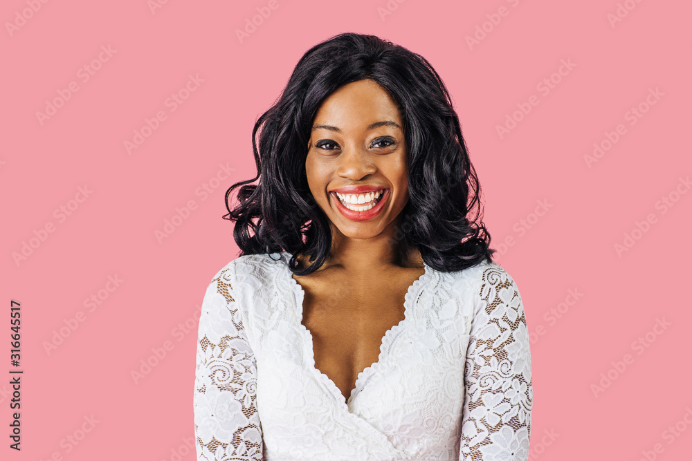 Wall mural close up portrait of a happy young smiling woman in sexy white lace dress looking at camera