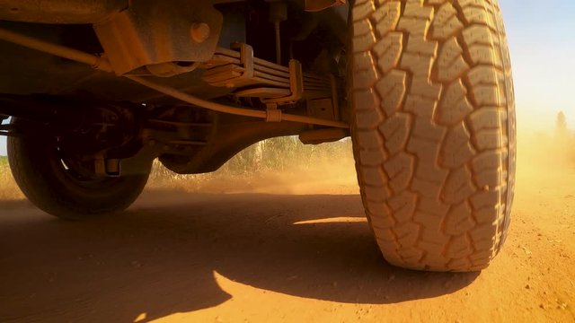 The rear wheels powertrain system of the 4 wheels off road drive light truck driving on dirt and dust ground