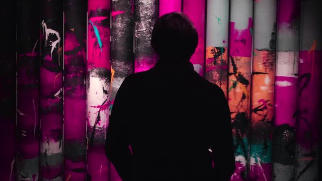 View from the back of man looking at the colorful paintings rotating on the rolls in the museum of Modern Art. Concept. Gallery in Saint Petersburg