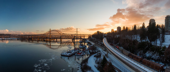 Aerial Panoramic View of the Modern City, Skytrain, Train and Fraser River during a colorful...