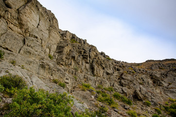 Fototapeta na wymiar Mountain landscape. Sheer cliff and sky. Travel and adventure.